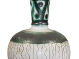 a green and white vase sitting on a white surface