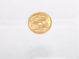 a gold coin in a clear box on a white surface