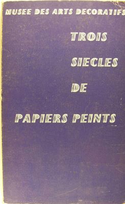 un vieux livre posé sur une table à côté d'un mur