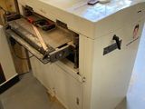 une machine qui se trouve dans un garage, avec un tuyau posé dessus