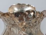 a silver vase that is sitting on a table