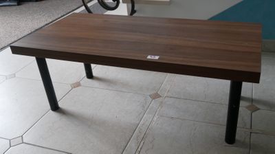 une table en bois aux pieds noirs posée sur un sol carrelé