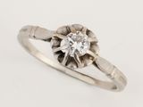 a close up of a diamond ring on a white surface