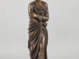 a bronze statue of a woman in a draped dress