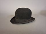 un chapeau noir orné d'un nœud, posé sur une table