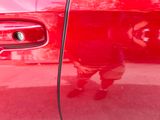 a reflection of a man in a red car