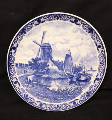 a blue and white plate with a windmill in the background