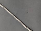 a close up of a silver and white bracelet on a black surface