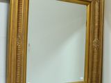 un miroir sur le mur au-dessus d'un lavabo dans une salle de bains