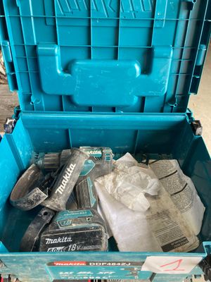 une boîte à outils bleue contenant des outils, posée par terre