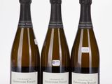 three bottles of champagne sitting next to each other on a white surface