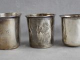 six silver cups are lined up in a row on a table