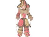 une image représentant une poupée vêtue d'une tenue rose et coiffée d'un chapeau marron