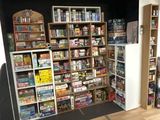 a room with a lot of books and games on the shelves