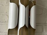 a white and gold lamp hanging on a brick wall