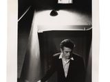 photographie en noir et blanc d'un homme en smoking debout dans un ascenseur