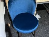 a blue chair sitting next to a white chair in a room