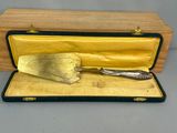 une spatule en or posée dans un étui sur une table