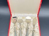 three silverware pieces in a red case on a table