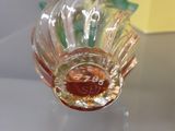 a glass vase that has a green leaf on top of it