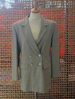 a suit on a mannequin stand in front of a screen