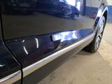 a close up of a car door handle with a car in the background