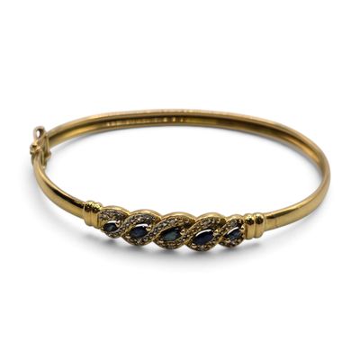 Gros plan sur un bracelet en or orné de pierres bleues