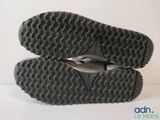 the soles of a pair of black shoes on a white surface