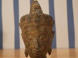 a statue of a buddha head on a wooden table