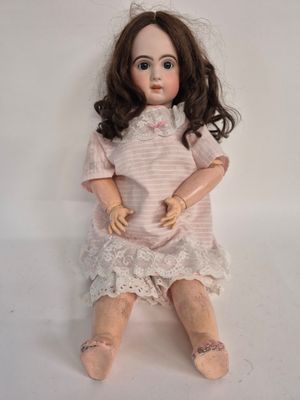 a doll that is sitting on a white surface