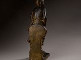 bronze statue of a woman sitting on a tree stump