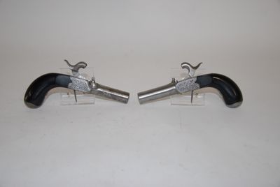 pair of black and silver revolvers on a white surface