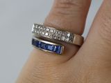 la main d'une femme tenant une bague sertie d'un diamant et d'un saphir