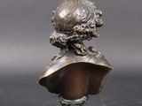 an antique bronze bust of a woman on a glass base