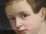 portrait of a young boy in a blue dress with a black background