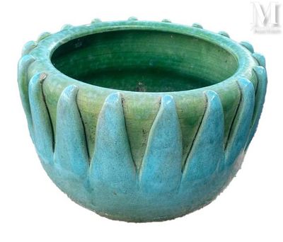 un vase vert posé sur une surface blanche