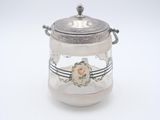 un bocal en verre ancien plaqué argent, orné d'un motif floral sur le couvercle
