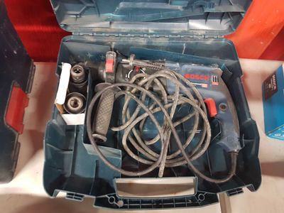 une perceuse filaire dans une boîte à outils posée sur une table