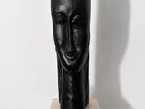 black sculpture of a woman ' s head on a black pedestal