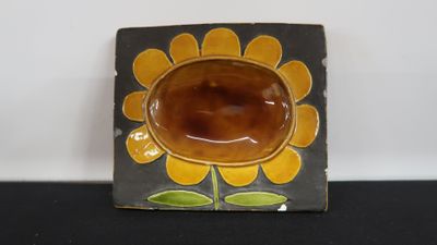 a small plate with a flower on it on a table