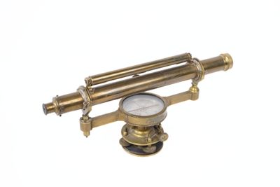 un télescope ancien en laiton, avec un cadran blanc sur fond blanc