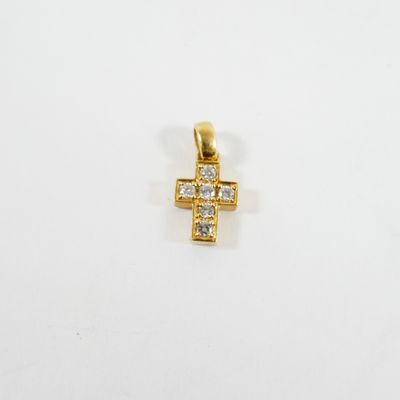 un pendentif en forme de croix en or serti de diamants sur fond blanc