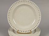 three white dinner plates with gold rims on a gray surface