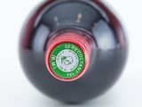 a close up of a bottle of wine on a white surface