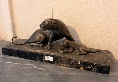 une statue représentant un chat et un chien, posée sur un socle en marbre