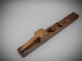 an old wooden plane with a wooden handle on a gray background