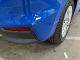 a close up of a blue car parked in a parking lot