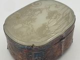 a silver box with a design on it on a white surface