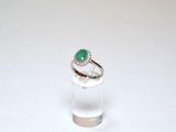a close up of a ring with a green stone in it