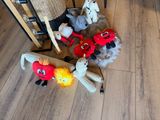 many stuffed animals that are on the floor next to a chair
